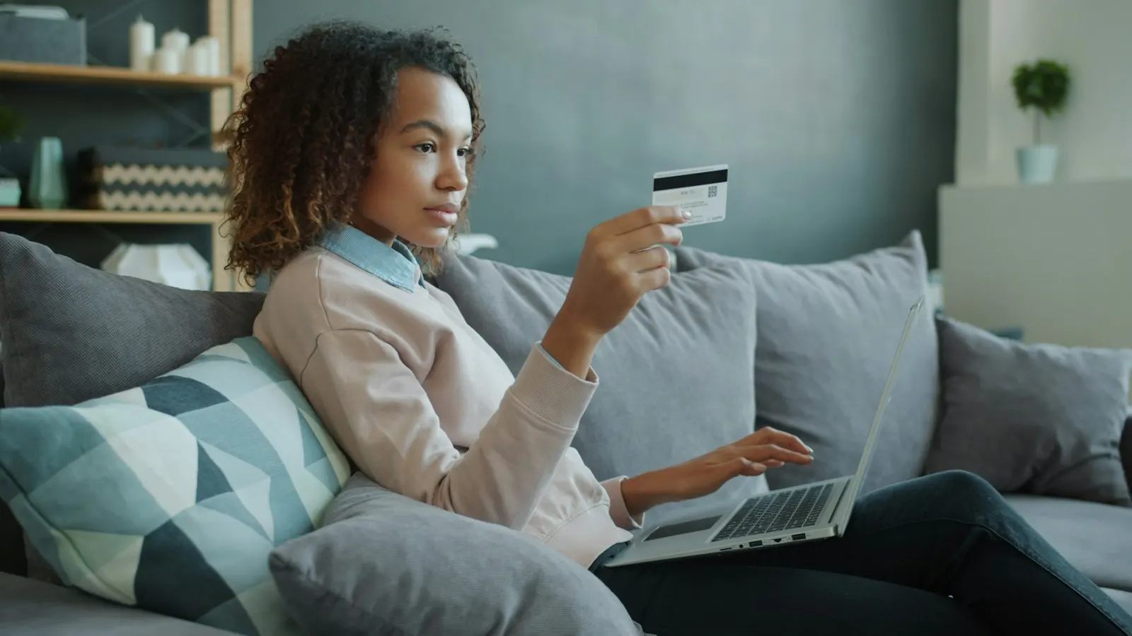 A woman on a sofa paying for an online order on her laptop